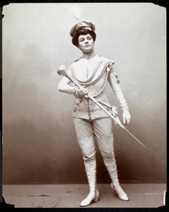 Une femme modélisant un uniforme de fanfare, tenant un bâton, vers 1898